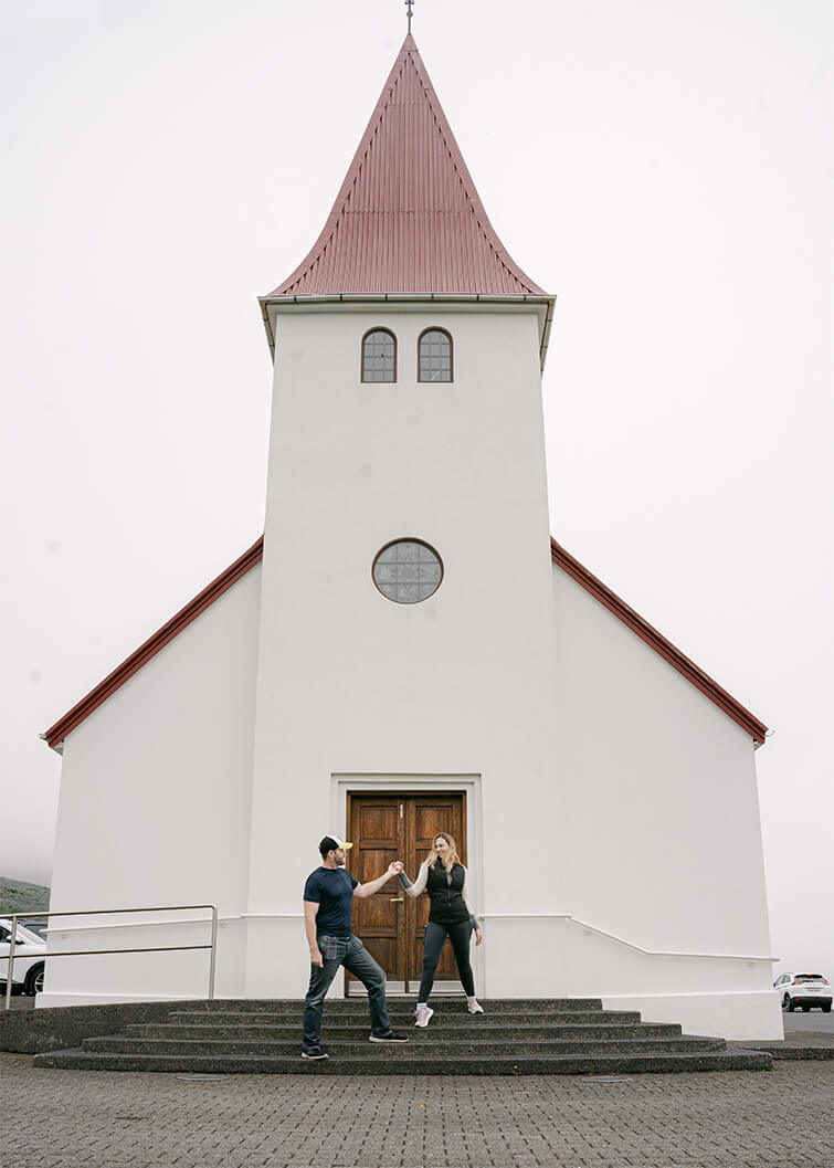 white church in Vik Iceland with couple on the steps