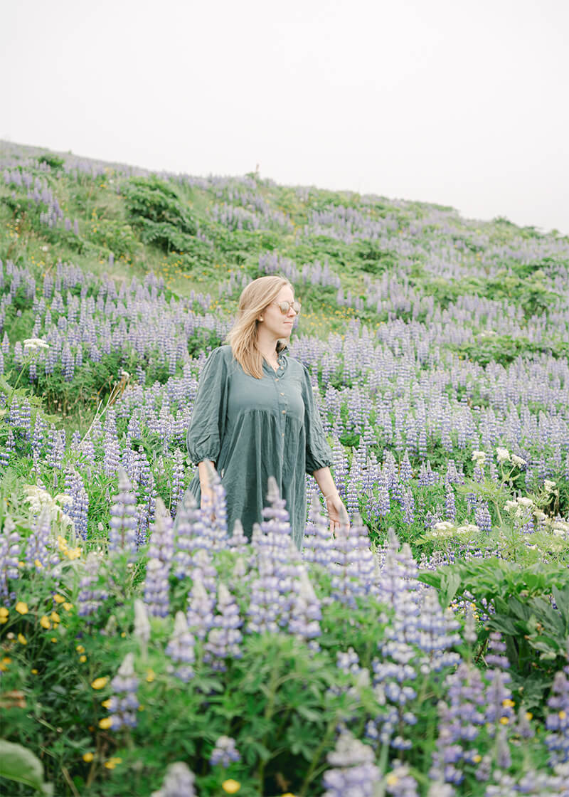 woman posing in flower field in Vik Iceland
