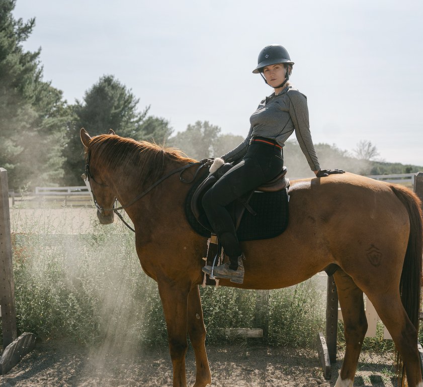 woman leaning back on horse
