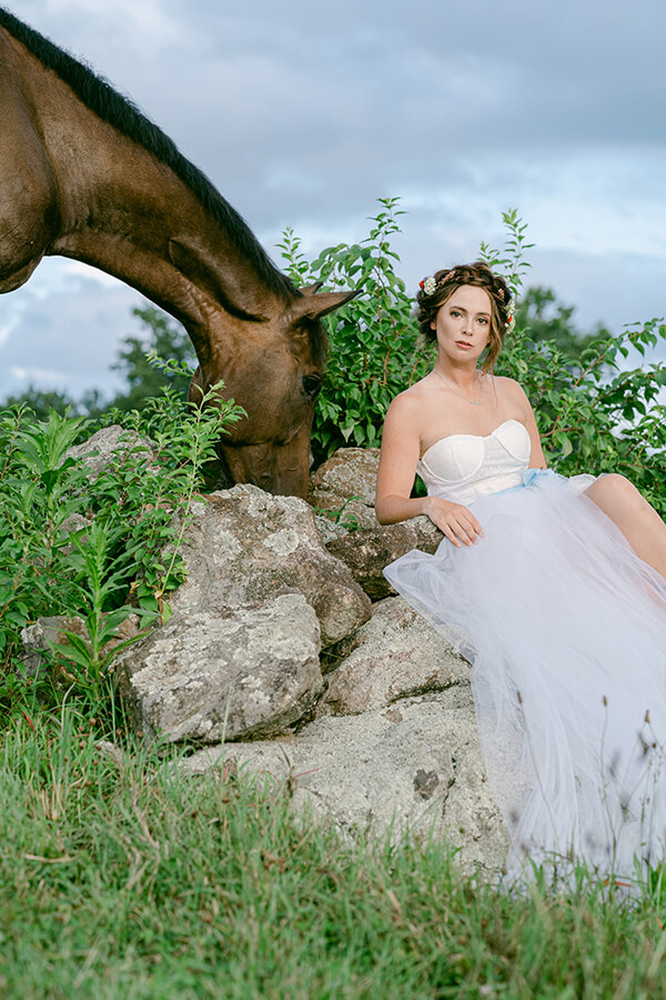 woman in field in ball gown with horse head