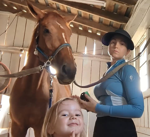 Horse in crossties with mom and daughter