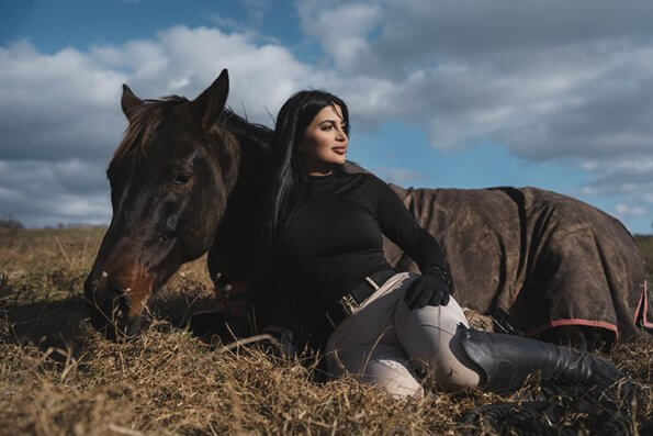horse laying in field with rider