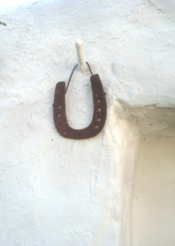 rusty horseshoe nailed to stucco walk