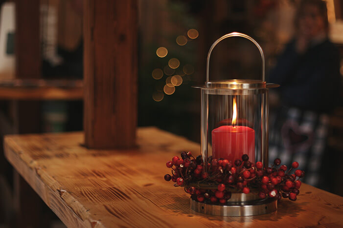red candle on a wooden table in a barn