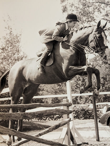 young Jackie Kennedy jumping with her horse