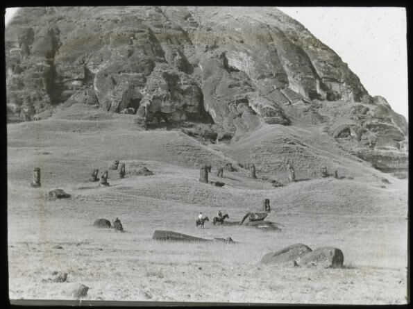 black and white image of horseback riders with Moai statues around them