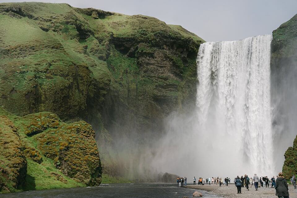 Iceland waterfall with tourists viewing