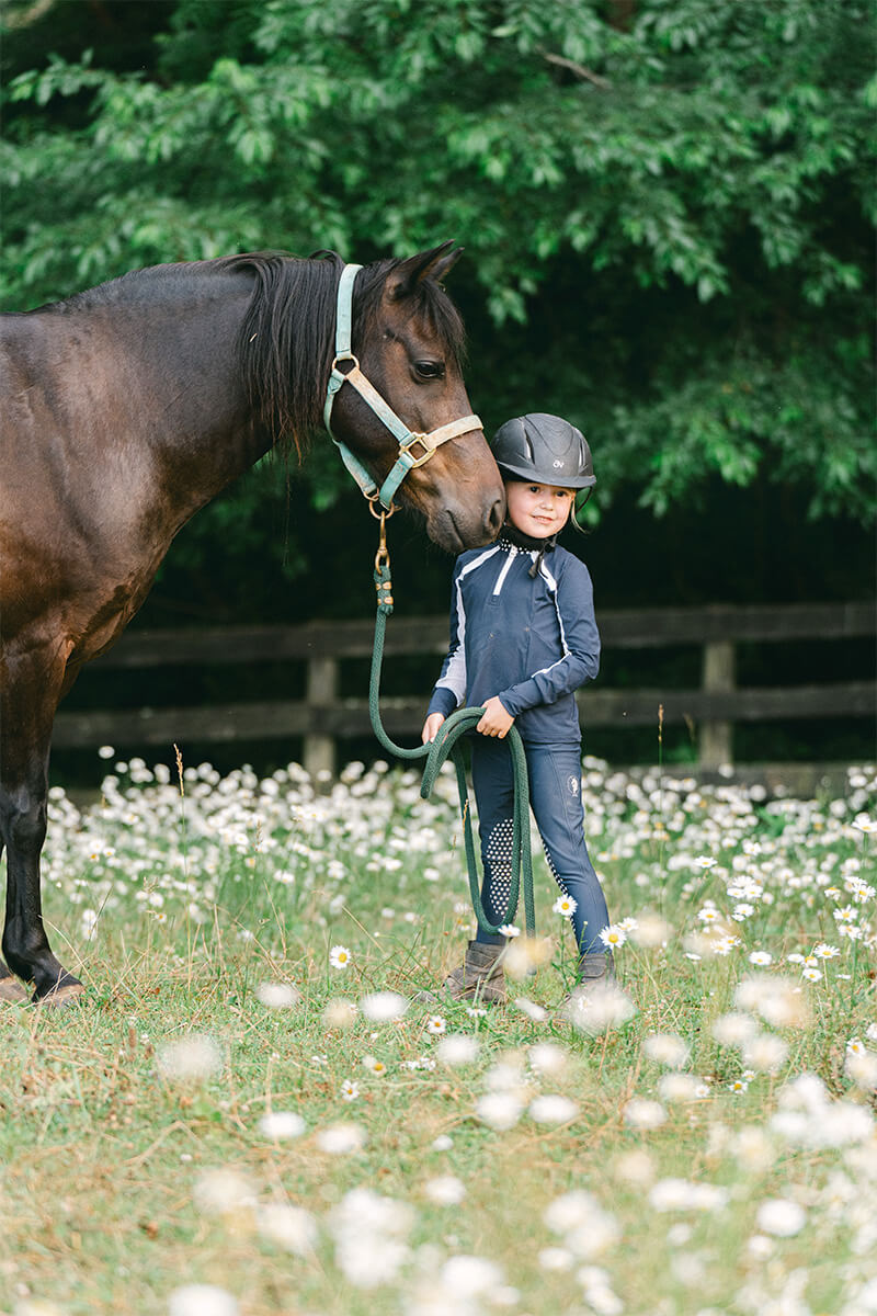 little girl with dark bay pony
