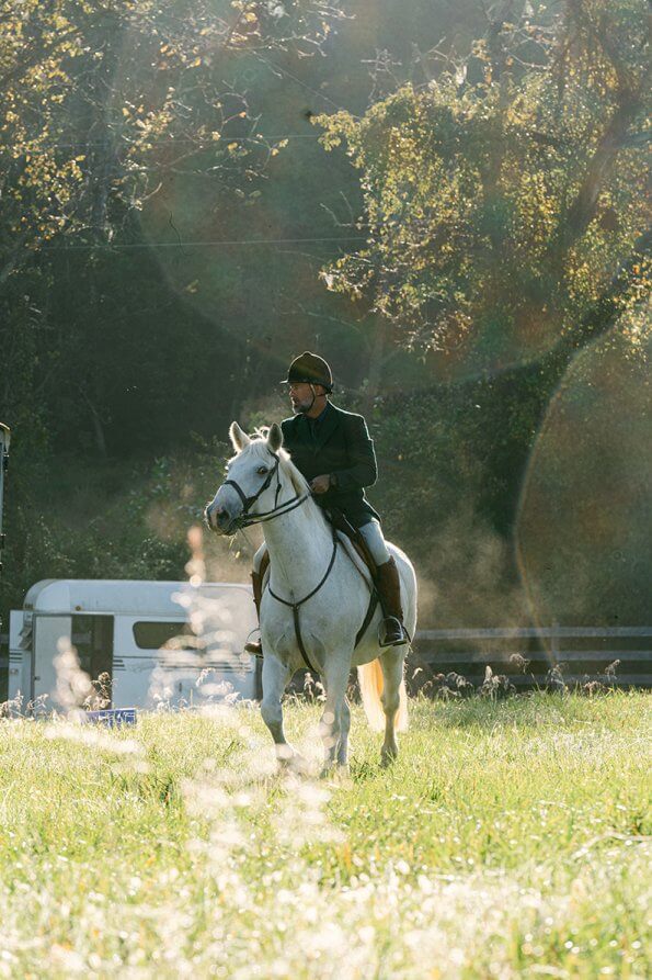 horse and rider walking through the grass preparing to start foxhunting